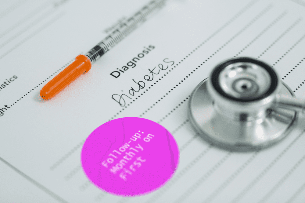 Stethoscope on a medical report with a diabetes diagnosis and a follow-up smart sticker