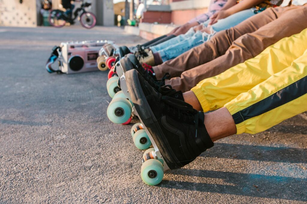 A group of friends relaxing in line with vibrant roller skates at an outdoor skatepark.
