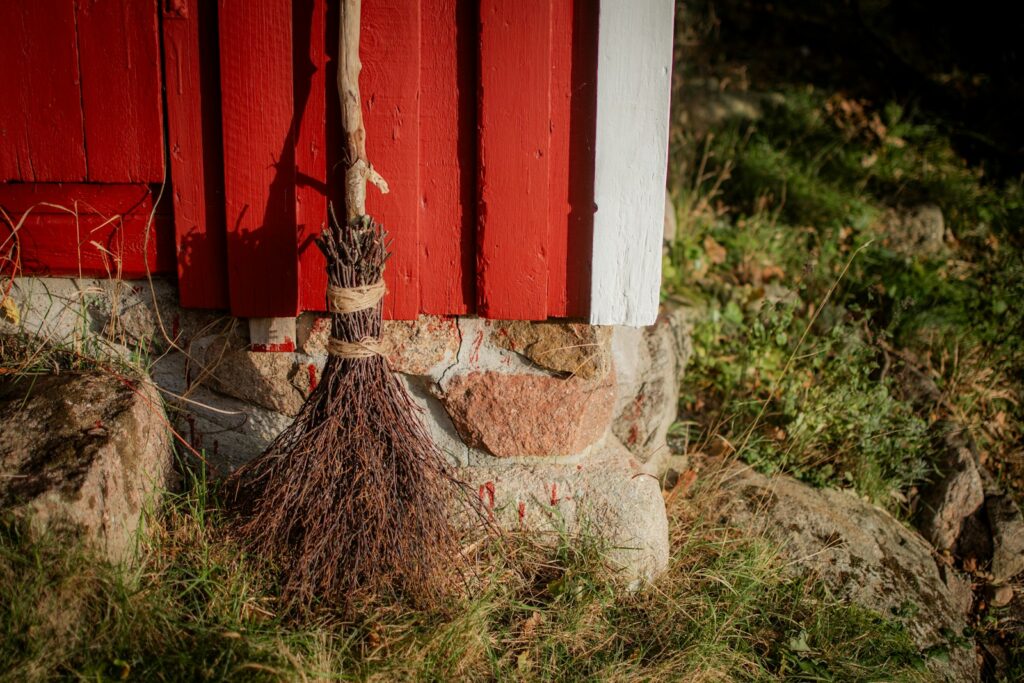 a broom leaning up against a red wall