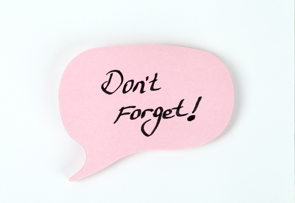 A pink speech bubble with the handwritten text "Don't Forget!" in black ink. The tone is friendly and serves as a helpful reminder.